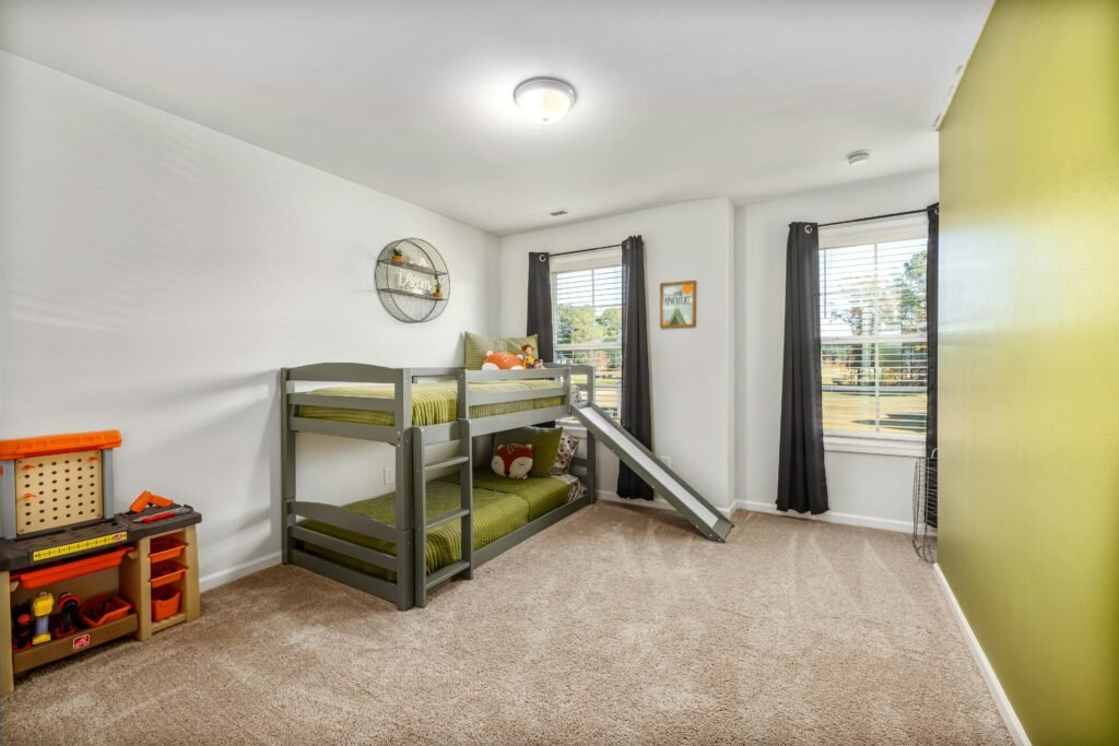 Bright and inviting child's bedroom featuring a bunk bed with a slide and a play area. Perfect for kids.